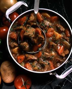 Hearty beef stew with vegetables in pot.