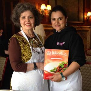 Two women holding a box of food in their hands.