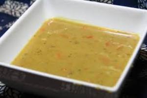 A bowl of soup is sitting on the table.