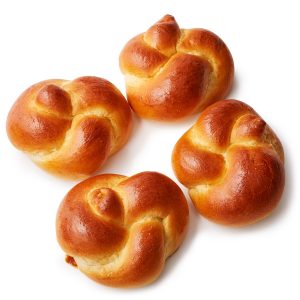 Four buns are sitting on a table.