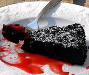 Chocolate cake slice with red sauce topping.