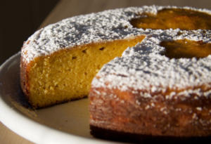 Powdered sugar cake with a slice missing.