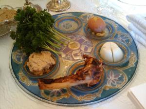 Seder plate with Passover symbolic foods displayed.