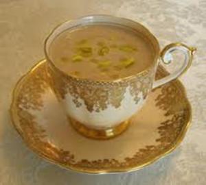 Elegant teacup filled with creamy beverage.