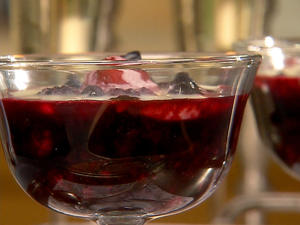 Glass bowl with dark berry dessert.