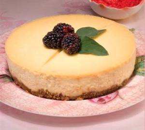 Creamy cheesecake garnished with blackberries and leaves
