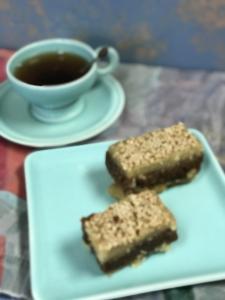 A plate with two pieces of cake and a cup of tea.