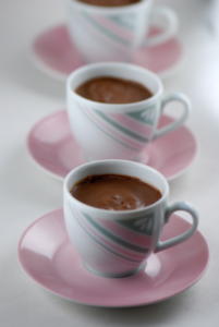 Three cups of hot cocoa on saucers.