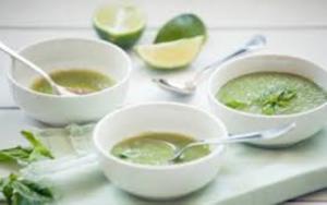 A bowl of soup with lime and cilantro.
