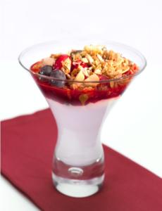 A glass of yogurt with granola and berries.