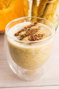 A glass of banana nut smoothie with nuts.