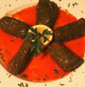 Stuffed grape leaves with tomato sauce.