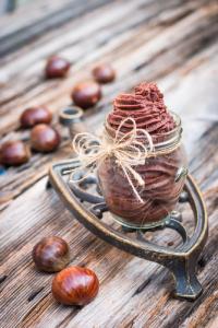 A wooden table with some nuts and a jar