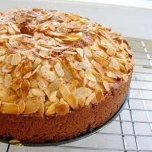 Round almond-crusted cake cooling on rack
