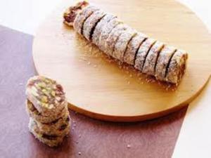 Sliced dessert roll with nuts on board.