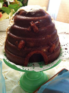 Beehive-shaped cake on green stand.
