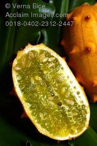 Kiwano fruit sliced open on green leaf.