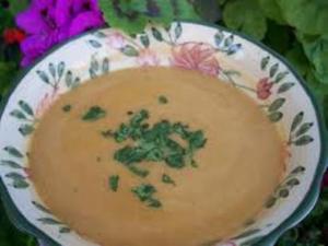 Soup in floral bowl with parsley garnish.