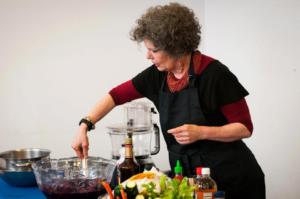 A woman in an apron is cooking food.