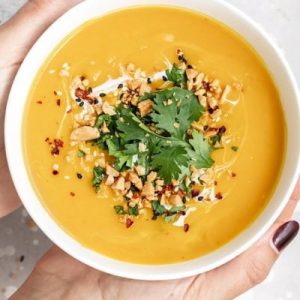 A person holding onto a bowl of soup
