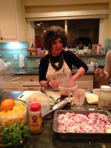 A woman in an apron preparing food on top of a table.