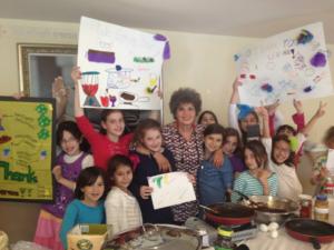 A group of children holding up signs in front of a woman.