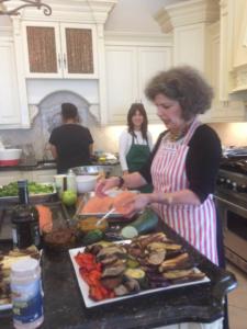 A woman in an apron preparing food at the counter.