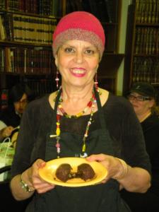 Woman smiling, holding a plate of food.