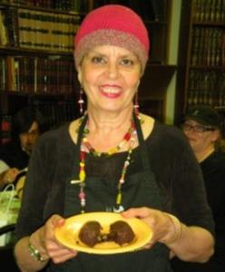 Smiling woman holding a plate of cake.