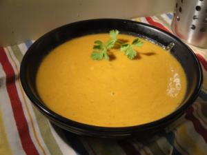 Creamy soup garnished with cilantro leaf.