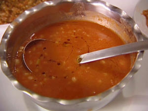 Spiced tomato curry with ladle in bowl