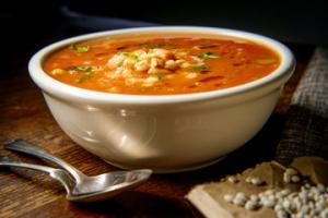 A bowl of soup with beans and other ingredients.