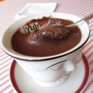 A bowl of chocolate pudding on a plate.