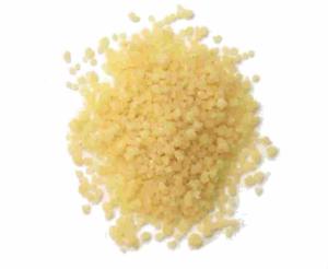 Small pile of yellow couscous on white.