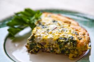 Slice of vegetable quiche on a plate.