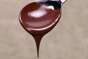 Spoon with dripping chocolate sauce.