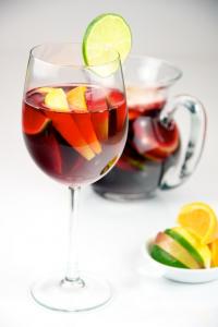 A glass of wine with fruit in it.