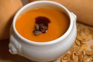Creamy pumpkin soup with seeds and garnish.