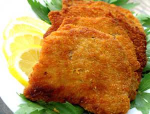 Breaded schnitzel with lemon slices and garnish.