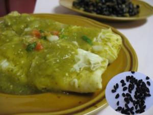 Enchiladas with green sauce and black seeds.