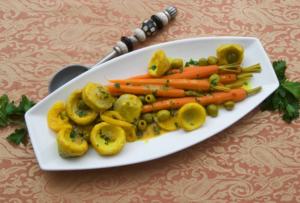 Carrots and artichokes on a white platter.