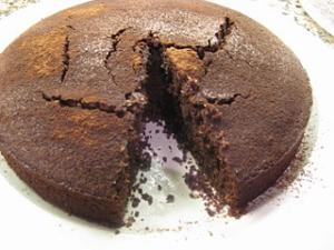 Cracked round chocolate cake with missing slice