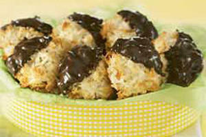 Chocolate-dipped coconut macaroons in green bowl