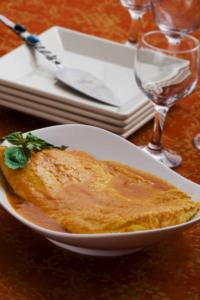 Omelette with sauce on elegant table setting.