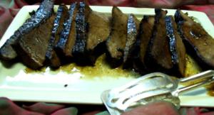 Sliced grilled meat on a white plate.
