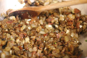 Cooking chopped vegetables and meat in pan.