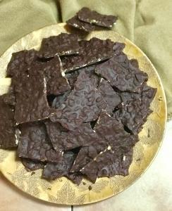 A plate of chocolate crackers on top of a table.
