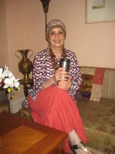 Woman sitting on sofa holding a cup.