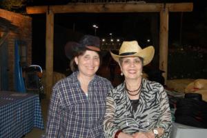Two women in cowboy hats posing for a picture.