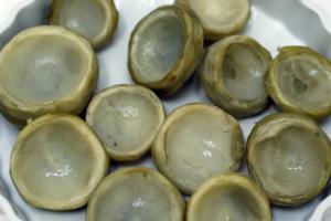 Artichoke hearts arranged on a white plate.